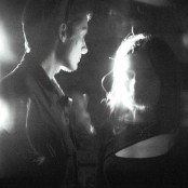 A blurry black and white image of a man & woman in black